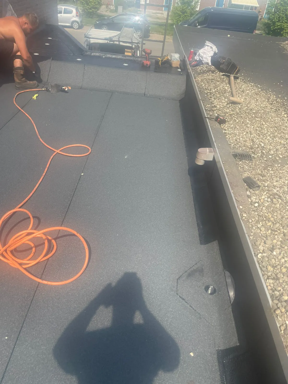 Nieuw bitumen plat dak op een uitbouw, strak afgewerkt